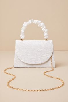 There is no easier way to elevate your springtime looks than with the Lulus Exceptional Class Ivory Lace Ruched Handle Mini Handbag! Chic floral lace (atop woven satin) shapes this cute mini bag that boasts a structured silhouette, a ruched satin top handle with gold beaded accents, and a flat bottom design. The front flap features a hidden magnetic closure that opens to reveal a lined, compact interior with a sidewall pocket. Attach the removable gold chain strap when you want a crossbody look! Lined. Bag measure 7. 75" wide, 5. 25" tall, and 2. 25" deep. 3. 25" drop. Chain measures 44" long. 100% Polyester. Imported. Lulus | Exceptional Class Ivory Lace Ruched Handle Mini Handbag | 100% Polyester. Cute Mini Bags, Bottom Design, Lulu Fashion, Mini Handbag, Satin Top, Mini Handbags, Ivory Lace, Personal Marketing, Gold Beads