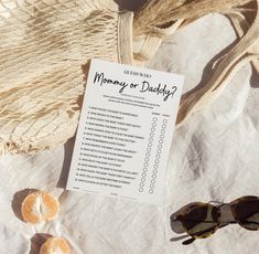 an orange sitting on top of a table next to sunglasses and a paper with the words mommy or daddy?