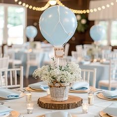 a table set up with plates, silverware and balloons in the air at a wedding reception