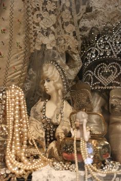 an assortment of fancy items on display in a store window, including purses and pearls