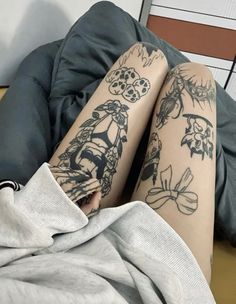 a person with tattoos on their legs laying down