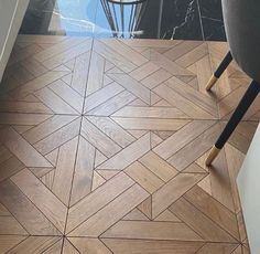 the floor is made up of wood and has an interesting pattern on it, as well as a chair