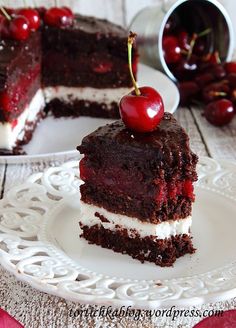 a piece of cake with cherries on top is sitting on a plate next to the rest of the cake