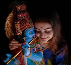 a woman is holding a small statue in her hands and looking down at the ground