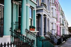 a row of multi - colored houses with wrought iron fences