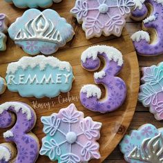 decorated cookies on a wooden platter with the number three in frosted icing