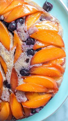 a blue plate topped with sliced peaches and blueberries