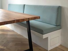 a wooden table sitting next to a blue couch on top of a hard wood floor