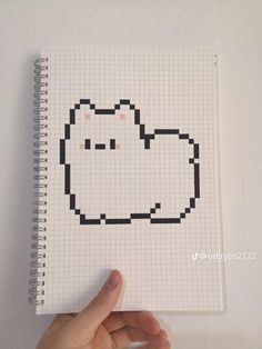 a hand is holding up a notebook with an image of a cat in the middle