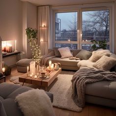 a living room filled with lots of furniture next to a large window covered in candles