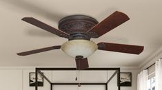 a ceiling fan in a bedroom with white walls and wood trimmings on the ceiling