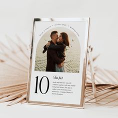 a photo frame with the number ten on it and a couple kissing in front of palm fronds