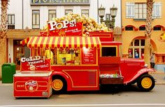 an old fashioned food truck parked in front of a building