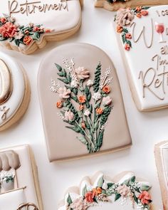 decorated cookies are arranged on a table with writing and flowers in the middle one cookie is shaped like a heart