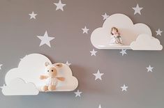 two white shelves with stuffed animals on them in the shape of clouds and stars against a gray wall