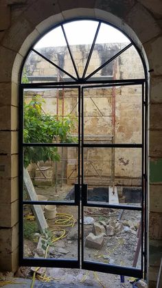 an arched glass window in the middle of a building with rubble and debris around it