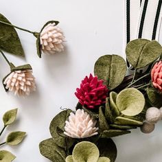 some flowers are laying next to each other on the table with ribbons and pins around them