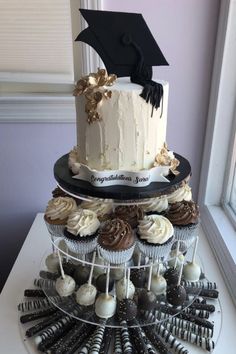 a graduation cake and cupcakes on a table