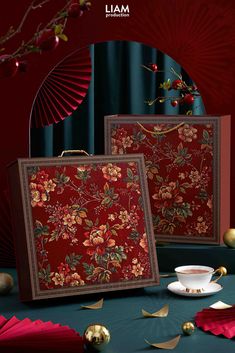 two pieces of red fabric with flowers and leaves on them, sitting next to each other