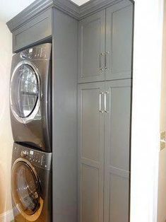 a washer and dryer are in the corner of this laundry room with cabinets