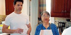 a man and woman standing in a kitchen next to each other with an apron on