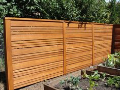 a wooden fence in the middle of a garden