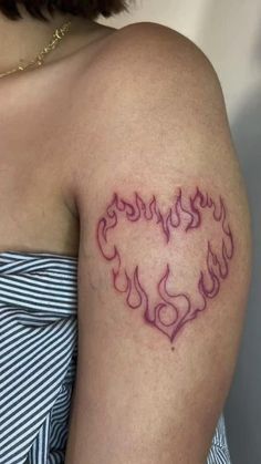 a woman with a tattoo on her arm that has flames in the shape of a heart