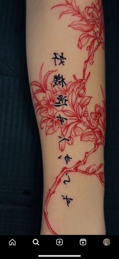 a tattoo with chinese writing and flowers on the side of a woman's leg