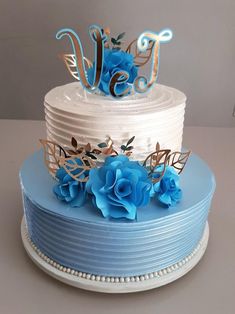 a three tiered cake with blue flowers on top