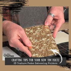 a person cutting out some gold paper with scissors