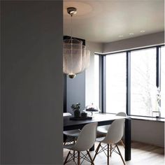 a dining room table with four chairs next to a large window