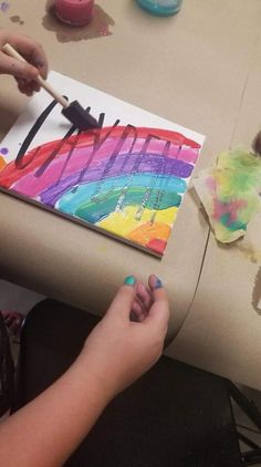 a child is painting on a piece of paper