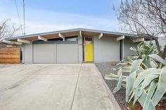 a yellow door sits in front of a gray house