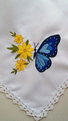 a blue butterfly and yellow flowers on a white handkerchief