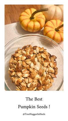 the best pumpkin seeds are in a glass bowl next to some pumpkins and squash