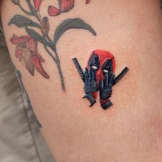 a close up of a person's thigh with tattoos on it and flowers behind them