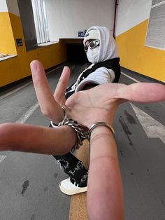 a person in a white mask is on a skateboard with his hands stretched out