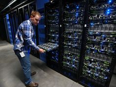 a man is looking at servers in a server room