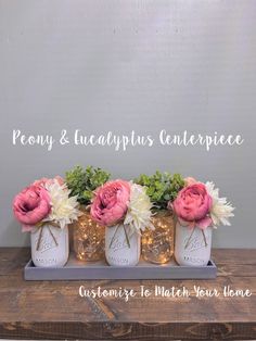 three mason jar vases with flowers in them on a wooden table next to the words peony and eucalyptusplus centerpiece