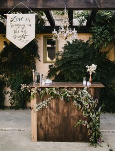 an outdoor bar is decorated with greenery and flowers