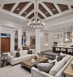 a living room filled with furniture and a chandelier hanging over the top of it