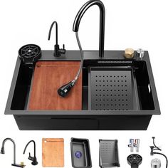 the kitchen sink is black and has wooden cutting board underneath it, along with other accessories