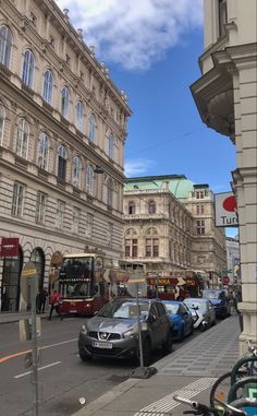 cars are parked on the side of the road in front of buildings and people walking