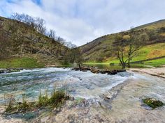 a river running through a lush green hillside