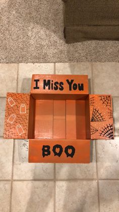 a cardboard box that says i miss you on the inside, and an orange box with writing in it