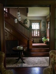 a living room filled with furniture next to a stair case