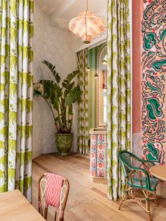 a dining room with colorful walls and curtains