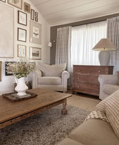 a living room filled with furniture and pictures on the wall