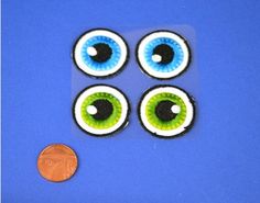 four fake eyes and one penny on a blue surface