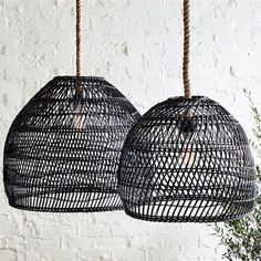 two hanging lights made out of black rattan